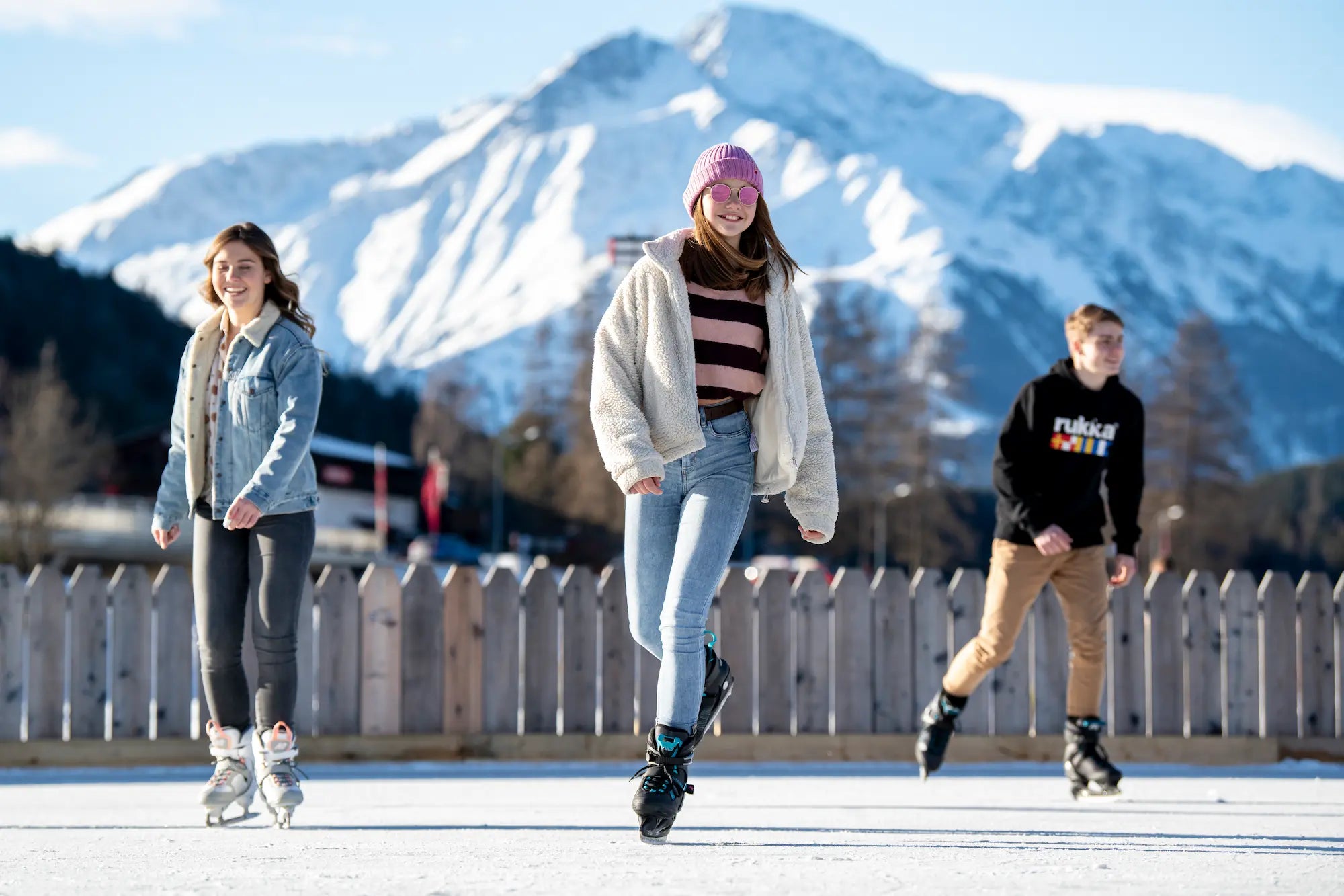 Drei junge Erwachsene beim Schlittschuhfahren