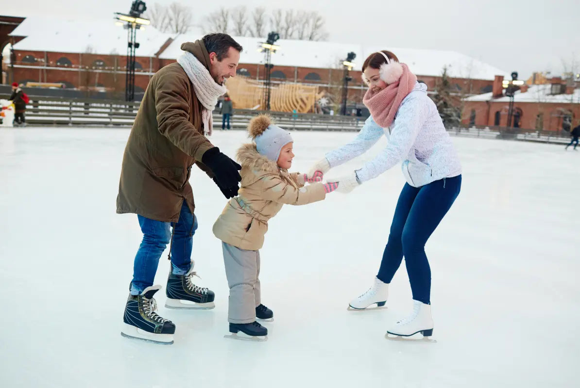 Eltern mit kleinem Kind beim Schlittschuhfahren