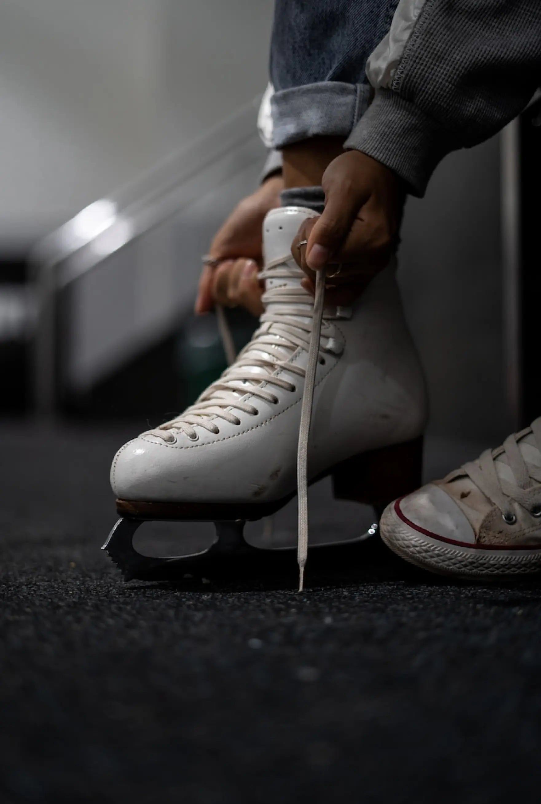 Frau zieht sich Schlittschuhe an