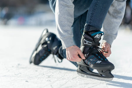 Mann bindet seine Schlittschuhe