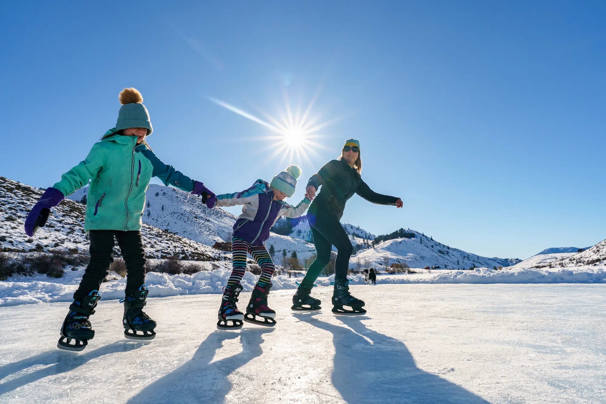 Mutter mit zwei Kindern beim Schlittschuhfahren auf gefrorenem See